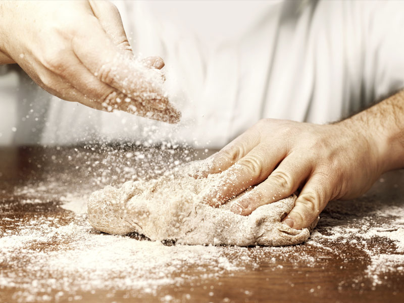 Close-up of a baker working with dough